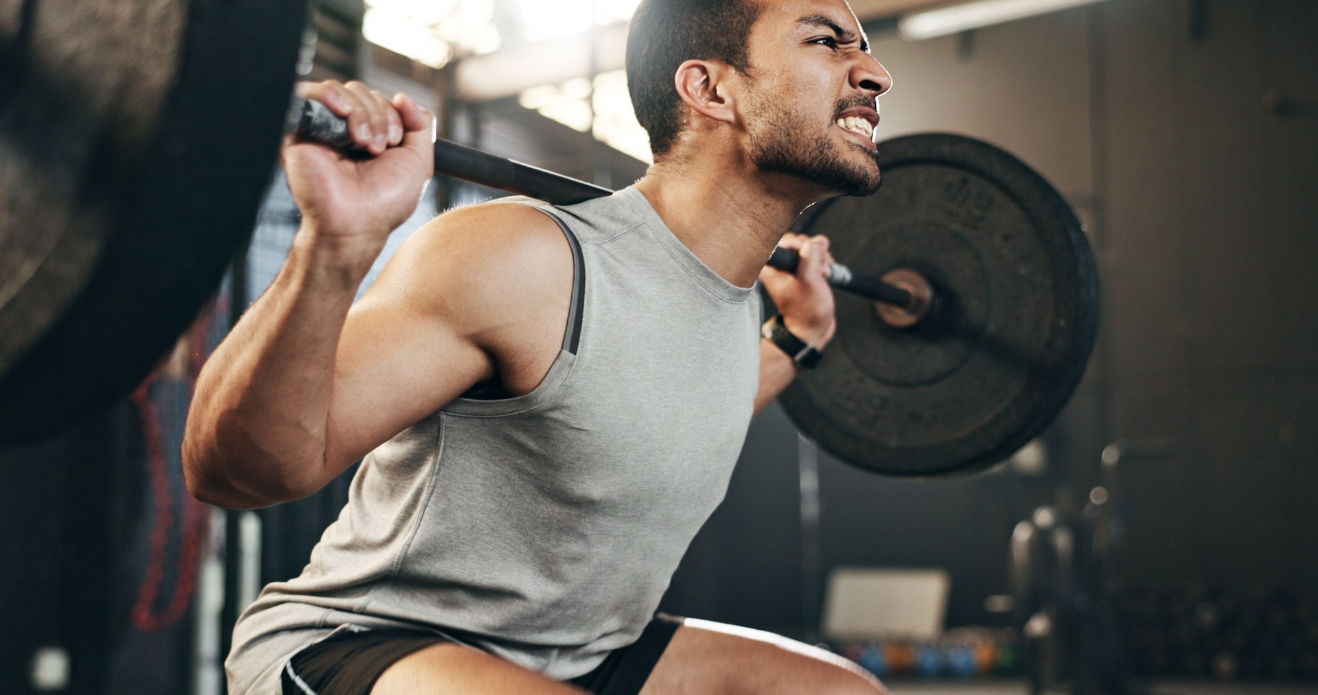 Man at gym, weight lifting and barbell with focus on muscle building endurance, strong body and balance power in fitness. Commitment, motivation and bodybuilder in workout for health and wellness.